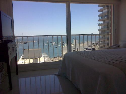 a bedroom with a large window with a view of a harbor at Edificio Kennedy in Punta del Este