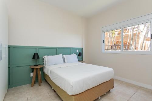 Una cama o camas en una habitación de Aquarelle by Viva - Prédio nos Ingleses pé-na-areia com piscina