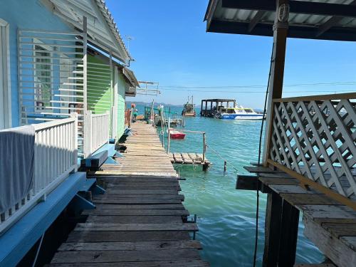 a wooden walkway leading to a house on the water at Koh Chang Baanrimtalay in Ko Chang
