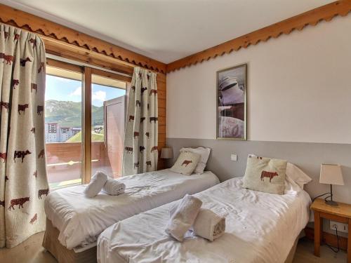 deux lits dans une chambre avec une fenêtre dans l'établissement Duplex 3 chambres avec piscine, fitness et parking couvert - FR-1-455-243, à Aime La Plagne