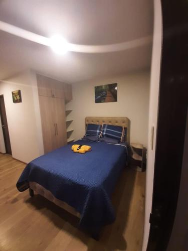 - une chambre avec un lit bleu et une serviette jaune dans l'établissement LOFT-STUDIO-en el PRADO-PISO 5, à Cochabamba