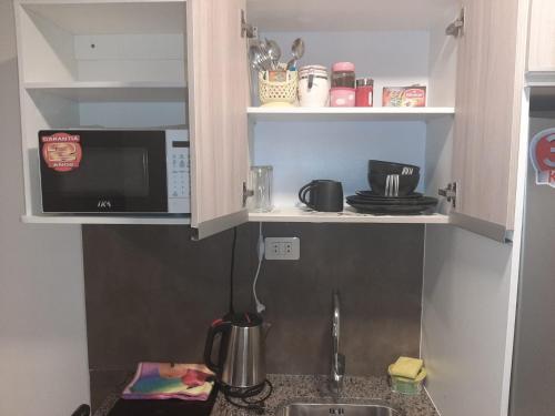 uma cozinha com um lavatório e um micro-ondas em LOFT-STUDIO-en el PRADO-PISO 5 em Cochabamba