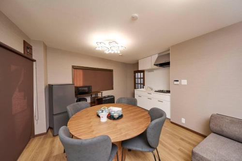 Zimmer mit einem Tisch und Stühlen sowie einer Küche in der Unterkunft ホテル八広 in Tokio
