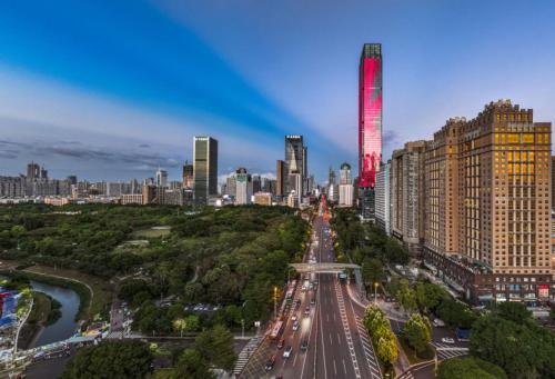 a city skyline with a red lighted skyscraper at The Skytel Hotel Shenzhen Central Park in Shenzhen