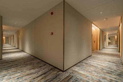 an empty corridor of an office building with a large wall at The Skytel Hotel Shenzhen Central Park in Shenzhen