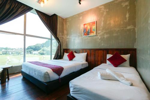 a hotel room with two beds and a window at Anggun Hotel in Seri Iskandar