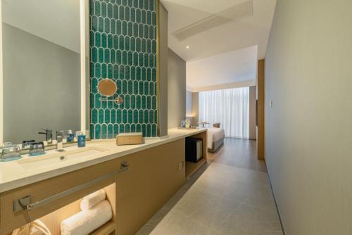 a bathroom with a sink and a large mirror at The Skytel Hotel Shenzhen Central Park in Shenzhen