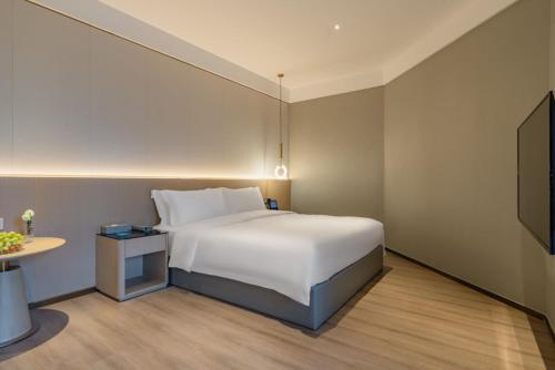 a hotel room with a bed and a table at The Skytel Hotel Shenzhen Central Park in Shenzhen