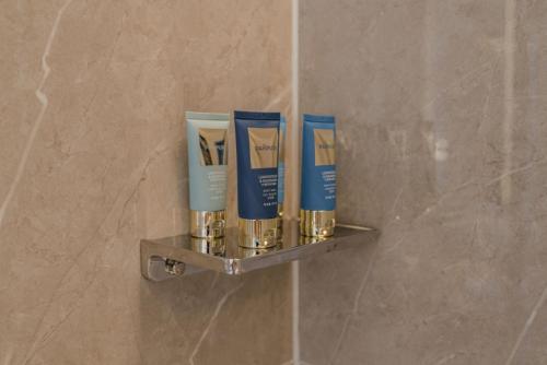 a shelf on a wall with three products on it at The Skytel Hotel Shenzhen Central Park in Shenzhen