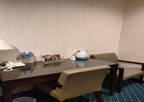 a desk in a hotel room with a table and chairs at Champion Hotel in Taipei