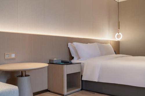 a hotel room with a bed and a table at The Skytel Hotel Shenzhen Central Park in Shenzhen