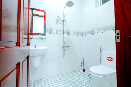a white bathroom with a toilet and a sink at The Luxury Pool Villa Vung Tau in Vung Tau