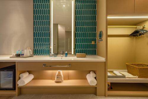 a bathroom with a sink and a mirror at The Skytel Hotel Shenzhen Central Park in Shenzhen