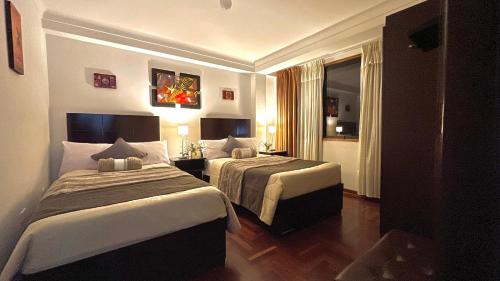 庫斯科的住宿－Allincay Cusco Apart Hotel，酒店客房设有两张床和窗户。