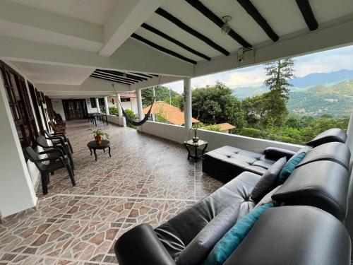 a living room with a couch and a large window at Palmeras del Mirador - Hotel Boutique Campestre en La Vega a 1h de Bogotá in La Vega