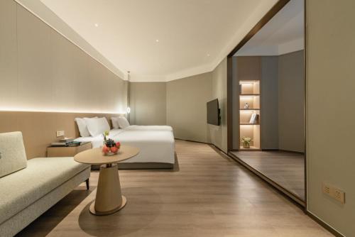 a hotel room with a bed and a couch at The Skytel Hotel Shenzhen Central Park in Shenzhen