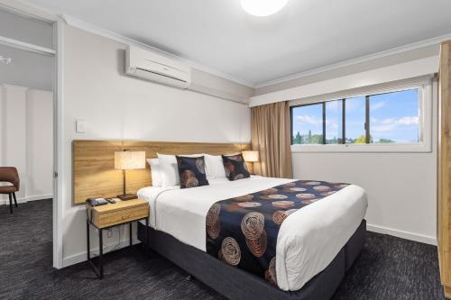 Habitación de hotel con cama y ventana en Econo Lodge North Adelaide, en Adelaida