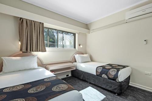 a hotel room with two beds and a window at Econo Lodge North Adelaide in Adelaide