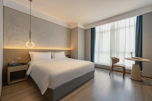 a hotel room with a bed and a table at The Skytel Hotel Shenzhen Central Park in Shenzhen