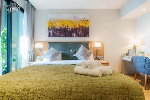 a bedroom with a large bed with a yellow blanket at Son&Henry Zenity District 1 in Ho Chi Minh City