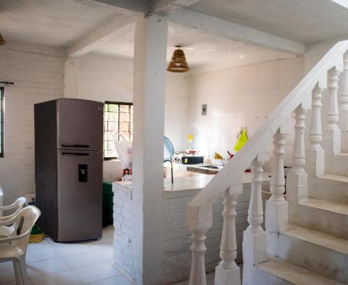 a kitchen with a staircase and a refrigerator at Cabaña la Arenosa in Coveñas