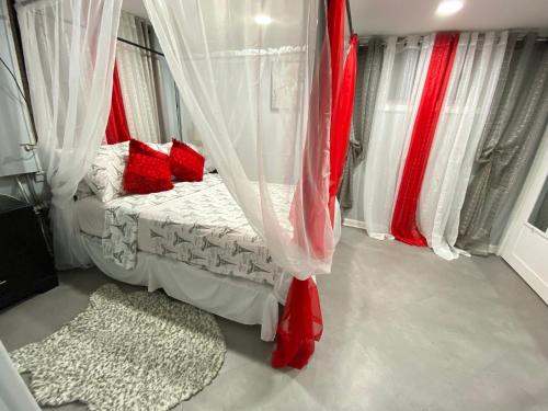 Schlafzimmer mit einem Bett mit roten Kissen und Vorhängen in der Unterkunft 1 New York City, The Best Gateway Vacations in North Bergen