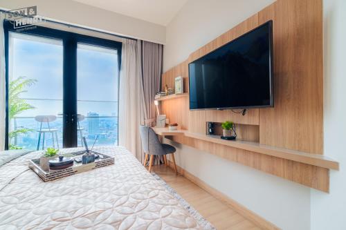 a hotel room with a large bed with a television on a wall at Son&Henry Zenity District 1 in Ho Chi Minh City