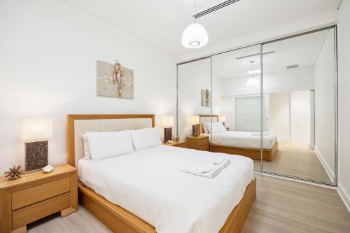 a bedroom with a large bed and a glass wall at Swainson at Del Monte in Henley Beach South