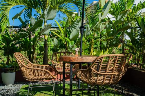 a table with chairs and an umbrella on a patio at LArtista Hostel in Puerto Princesa City