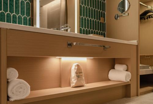 a bathroom with a vanity with towels and a mirror at The Skytel Hotel Shenzhen Central Park in Shenzhen