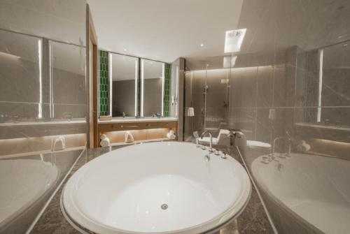 a large bathroom with a large tub and a sink at The Skytel Hotel Shenzhen Central Park in Shenzhen