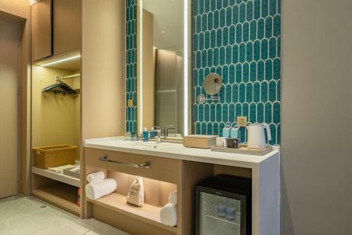 a bathroom with a sink and a mirror at The Skytel Hotel Shenzhen Central Park in Shenzhen