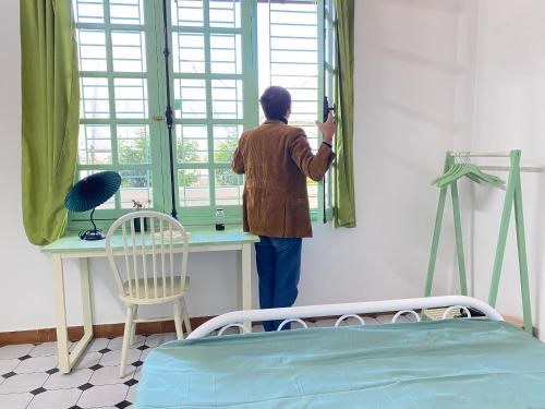 a man taking a picture in a hospital room looking out the window at The Green Burrow - Nhà vườn mùa hè Đà Lạt in Da Thanh