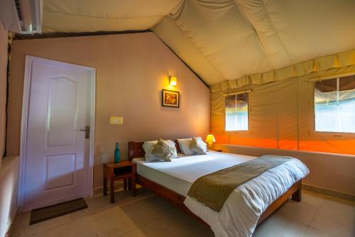 A bed or beds in a room at Banyan By The Ganges