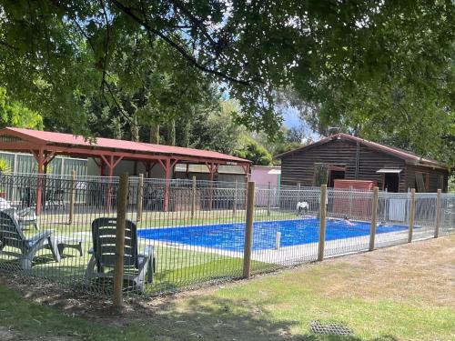a fence next to a swimming pool with a building at High Country Holiday Park in Mansfield