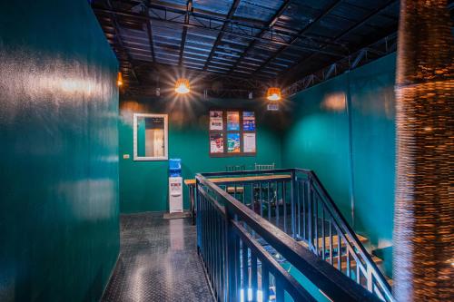 a hallway with a green wall and a stair case at LArtista Hostel in Puerto Princesa City