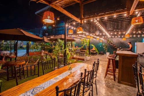 a restaurant with a long wooden table and chairs at LArtista Hostel in Puerto Princesa City