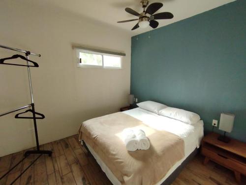a bedroom with a bed with two white towels on it at El Cedro y su comodidad in Loreto