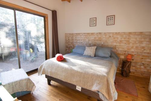 een slaapkamer met een bed en een groot raam bij Lodge Terra Mar in Pichilemu