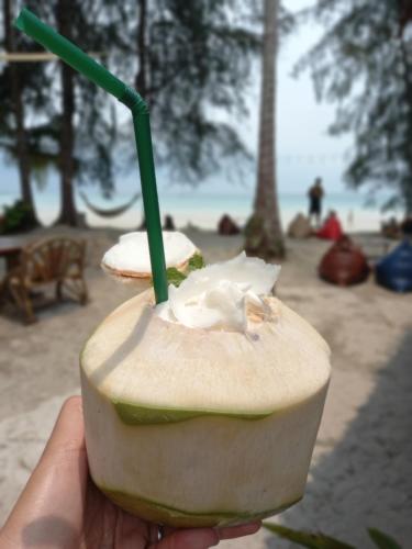a hand holding a sandwich with a green straw at Koh Kood Club in Ko Kood