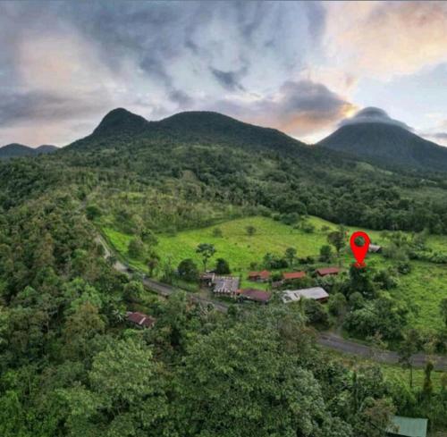 a red balloon is flying over a green mountain at Flora Glamping de Abuela in Fortuna