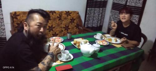 a man and woman sitting at a table eating food at Green House Yala in Kirinda