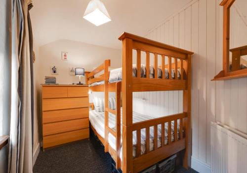 ランベリスにあるJentrea Cottageのベッドルーム1室(二段ベッド2台、ドレッサー付)