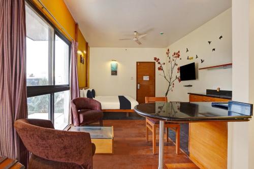 een hotelkamer met een bed en een tafel en stoelen bij Astra Hotels & Suites - Marathahalli in Bangalore
