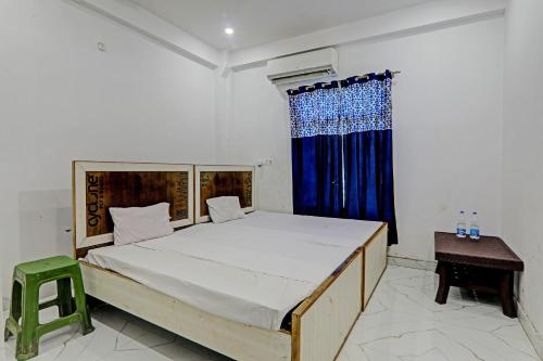 - une chambre avec un grand lit et un rideau bleu dans l'établissement OYO ONCE MORE RESTAURANT AND CAFE, à Lukerganj