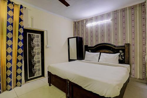 a bedroom with a bed with white sheets at Hotel Crystal INN in New Delhi