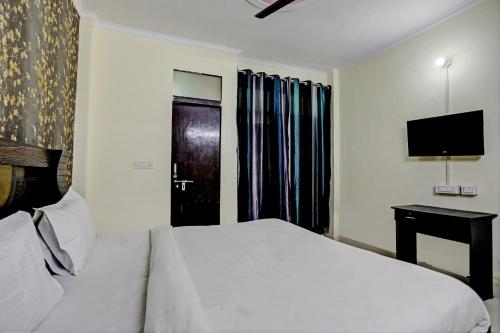 a hotel room with a bed and a television at Hotel Crystal INN in New Delhi
