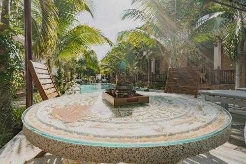a circular table with a fountain in front of a pool at Valentina Resort & Spa Phu Quoc in Phu Quoc