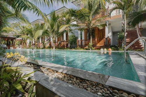 Valentina Resort & Spa Phu Quoc في فو كووك: مسبح بالنخيل ومنزل