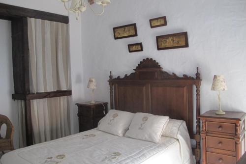 a bedroom with a bed with a wooden head board at Casa Las Torres in Medina de las Torres
